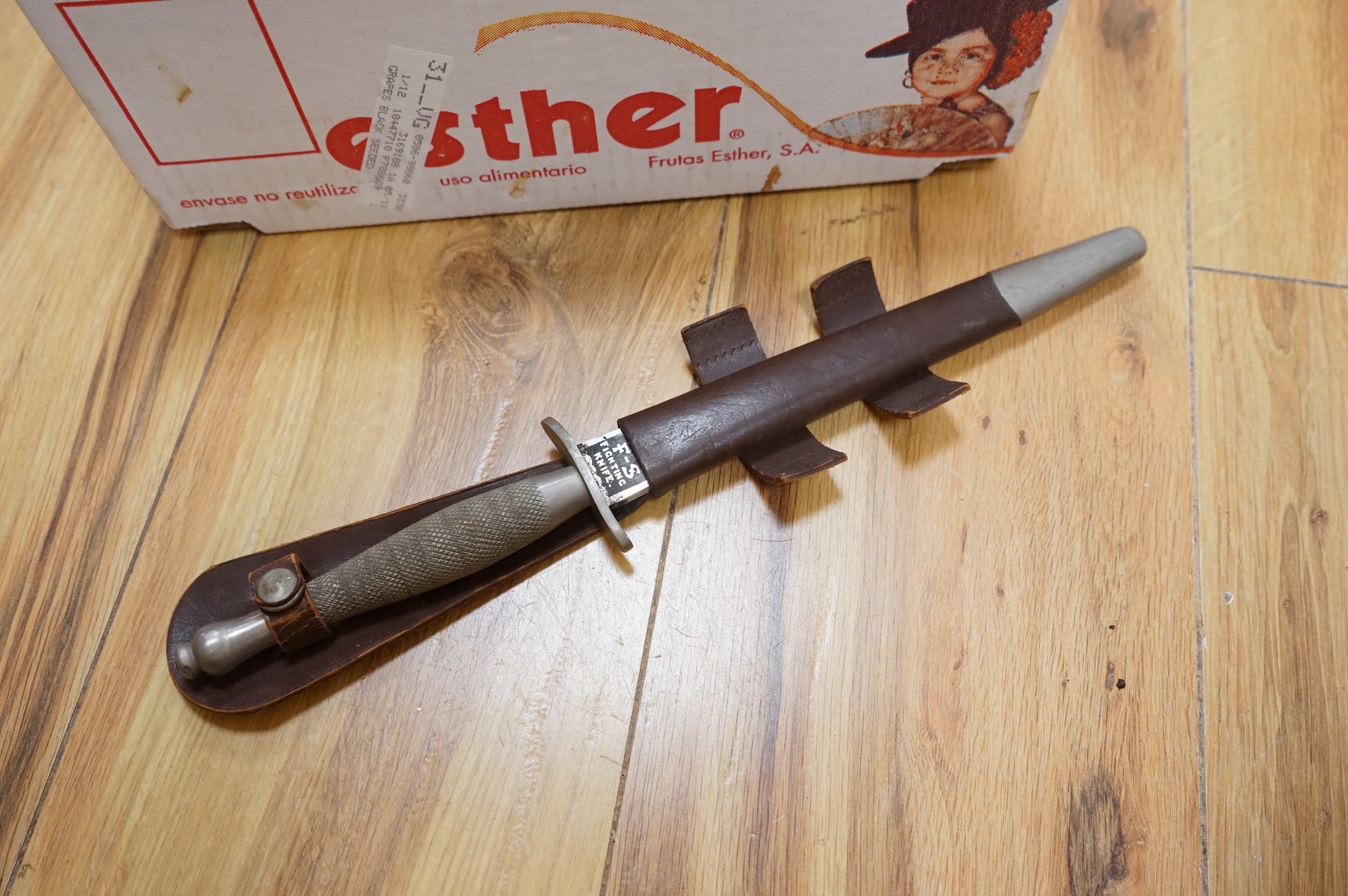 A Sykes-Fairburn Fighting Knife by Wilkinson sword in its leather scabbard, together with a 1942 Mk.III military compass by T.G.Co.Ltd. in a webbing pouch dated 1940, together with another compass, a telescope in a leath